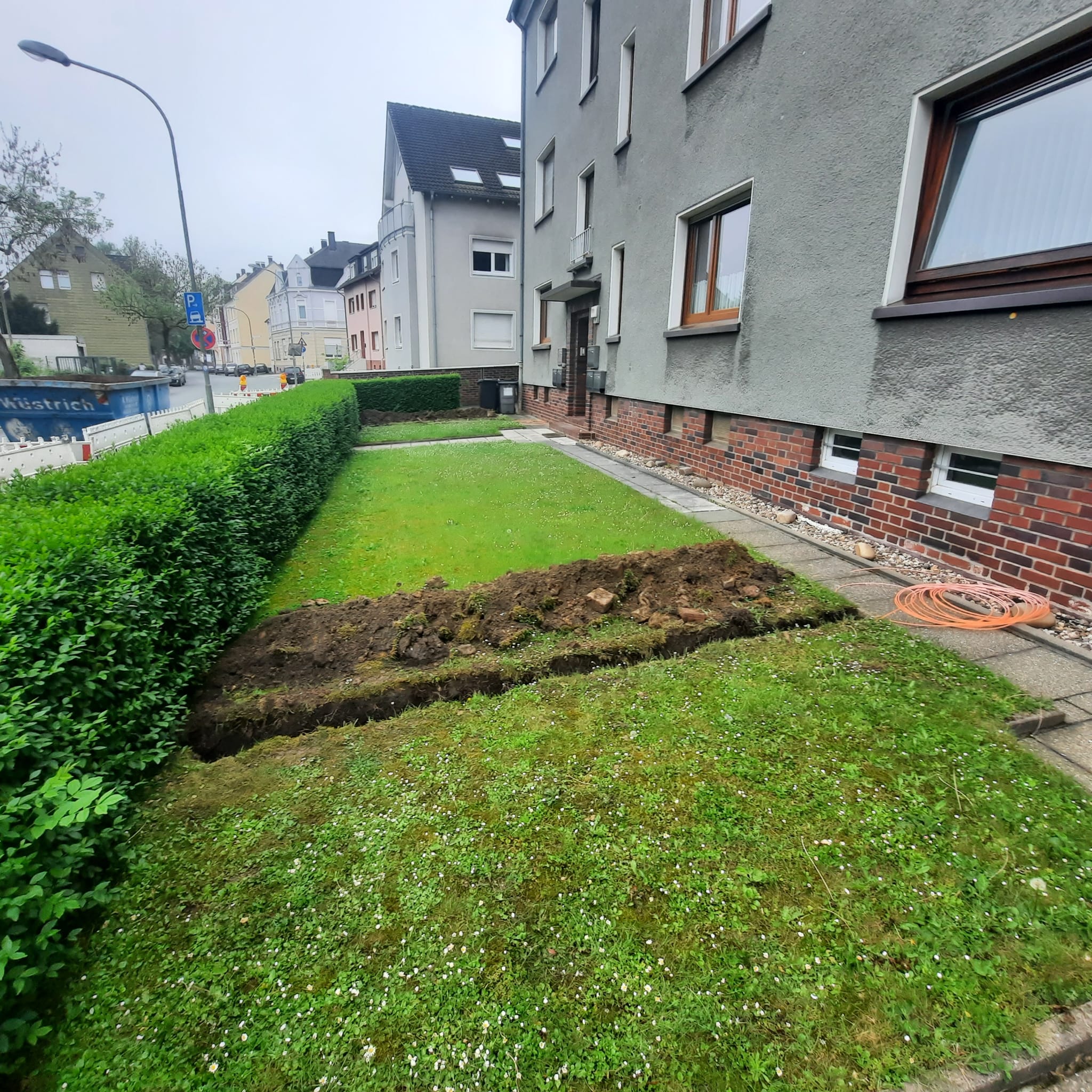 Graben für Drainageleitungen in einer Rasenfläche