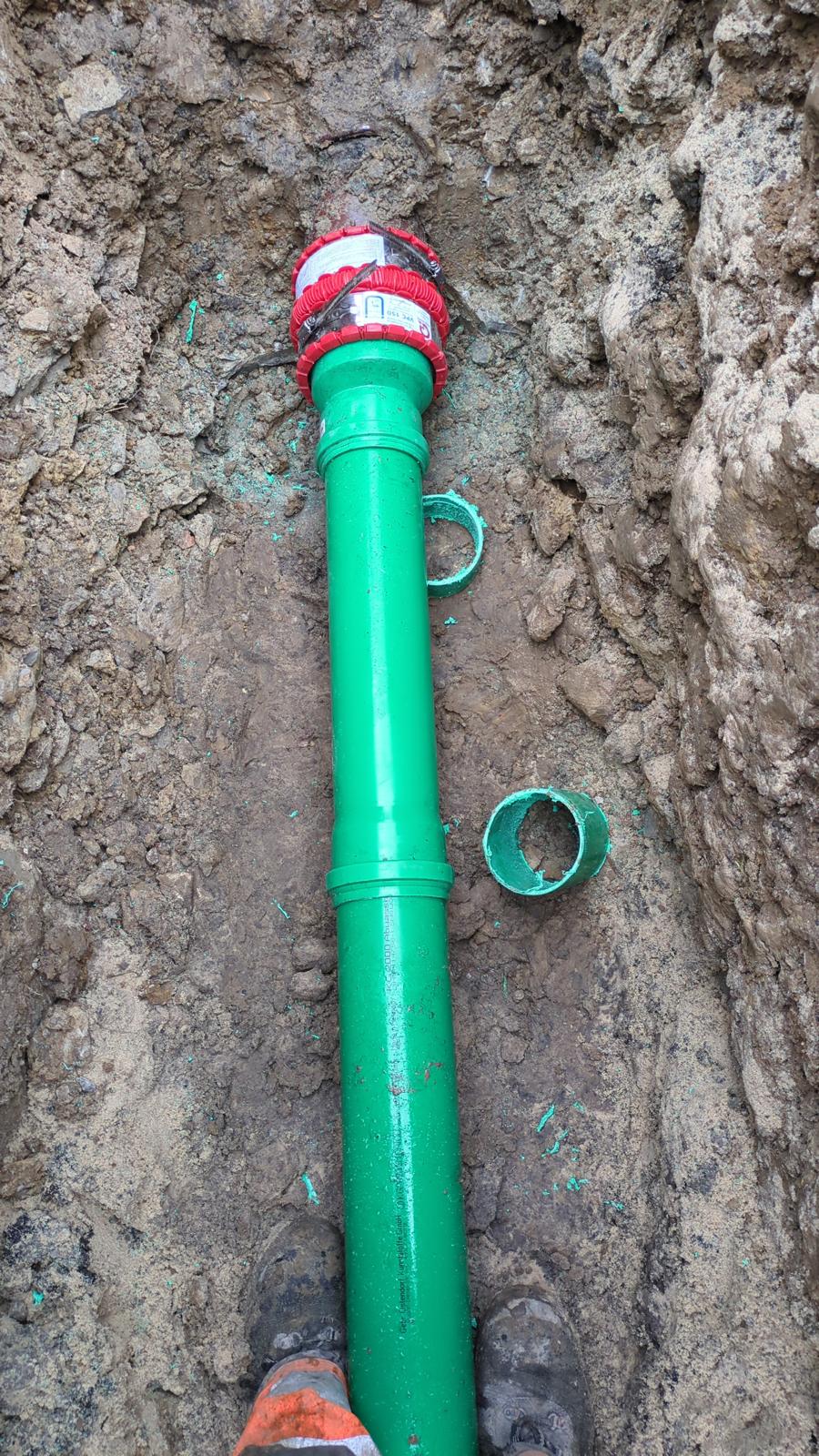 Grünes Druckrohr im Graben